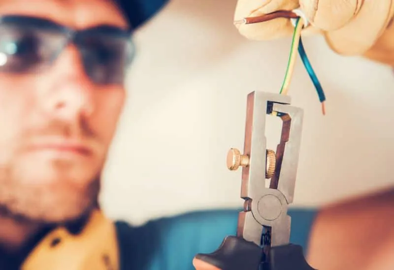 Electrician stripping and connecting wire for a new outdoor electrical hookup